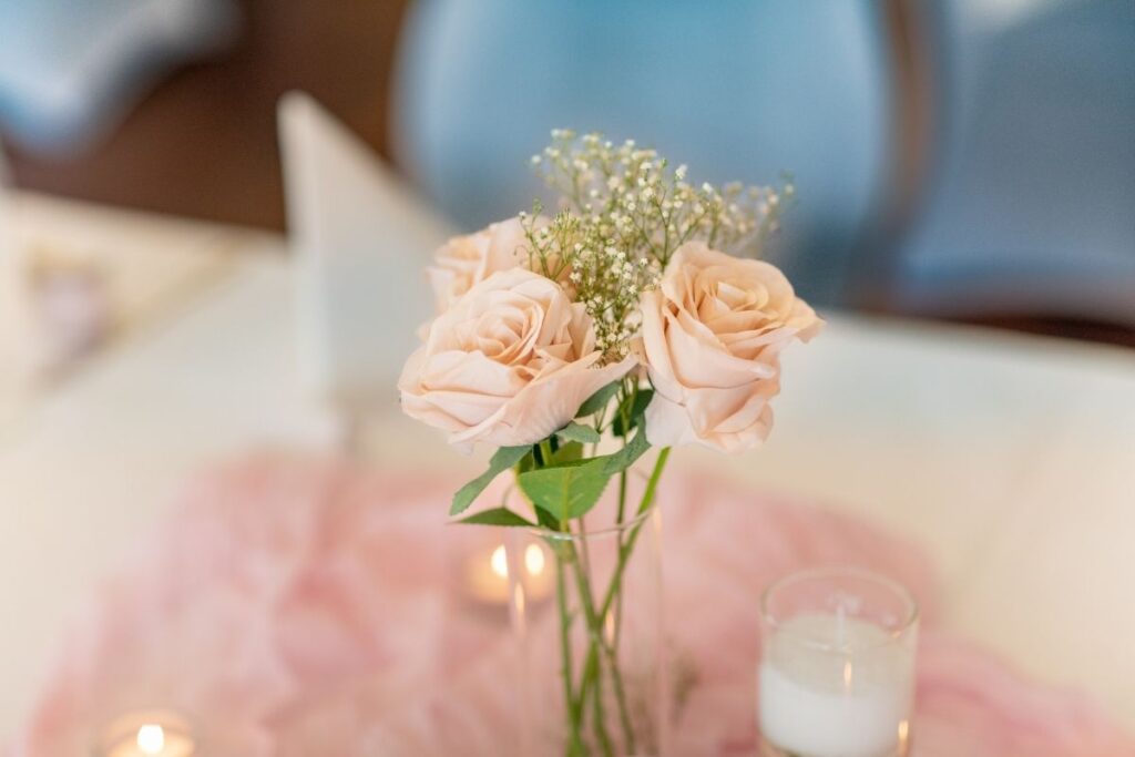 Tischdekoration Hochzeit – zarte Rosen in Glasvase mit Kerzenlicht