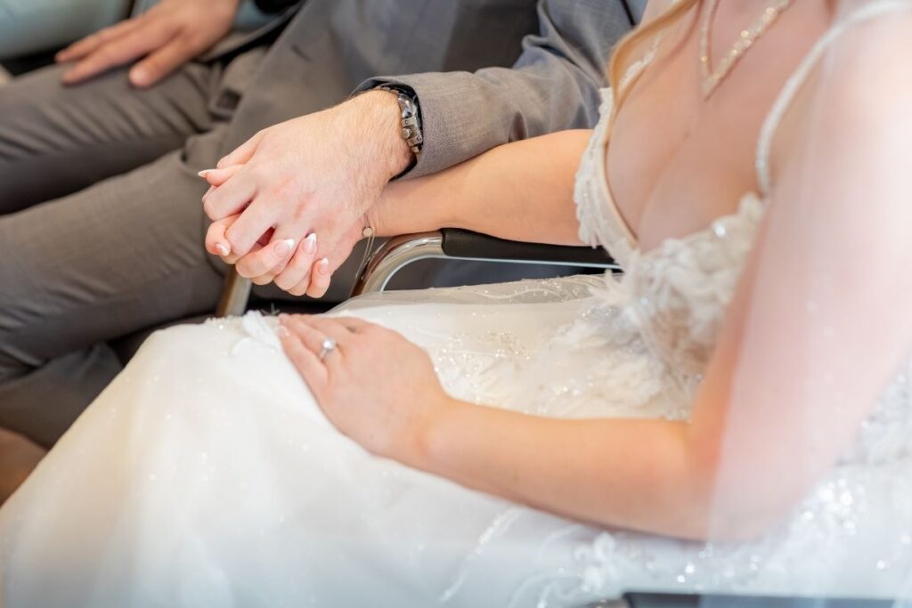 Nahaufnahme der Hände von Braut und Bräutigam, die sich während der Trauung halten