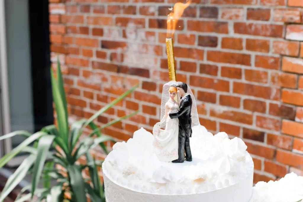 Hochzeit Jaspershof Westerstede – weiße Eistorte mit Brautpaarfigur und goldener Wunderkerze